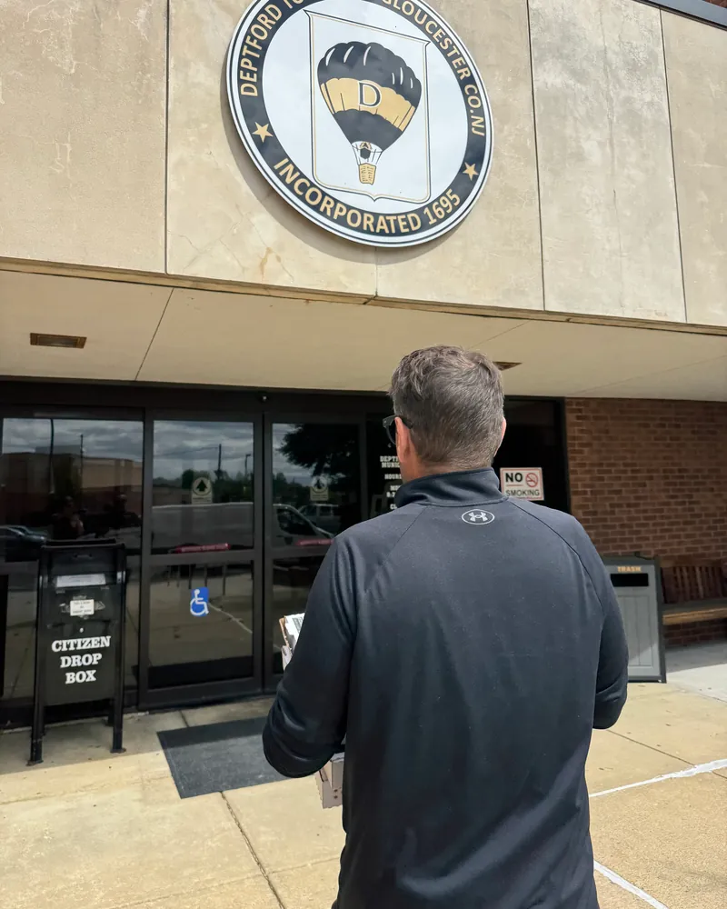 Eric walking into the Deptford Township municipal building carrying boxes of treats