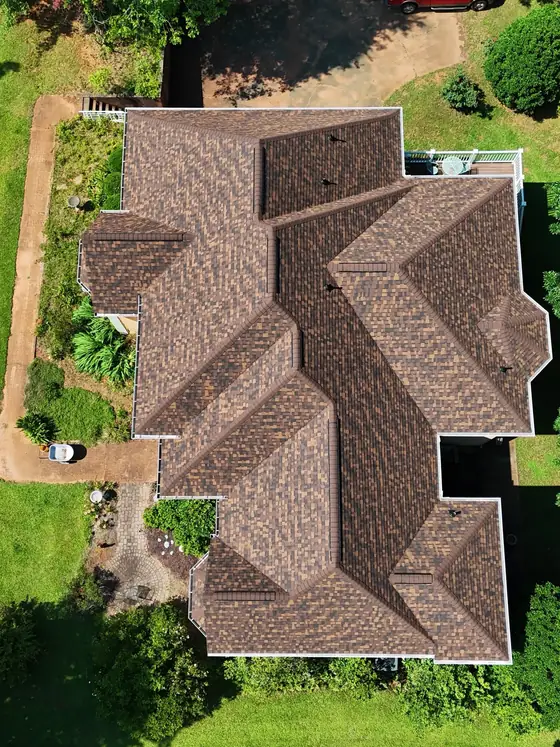 New brown shingle roof on a large hip-roof home