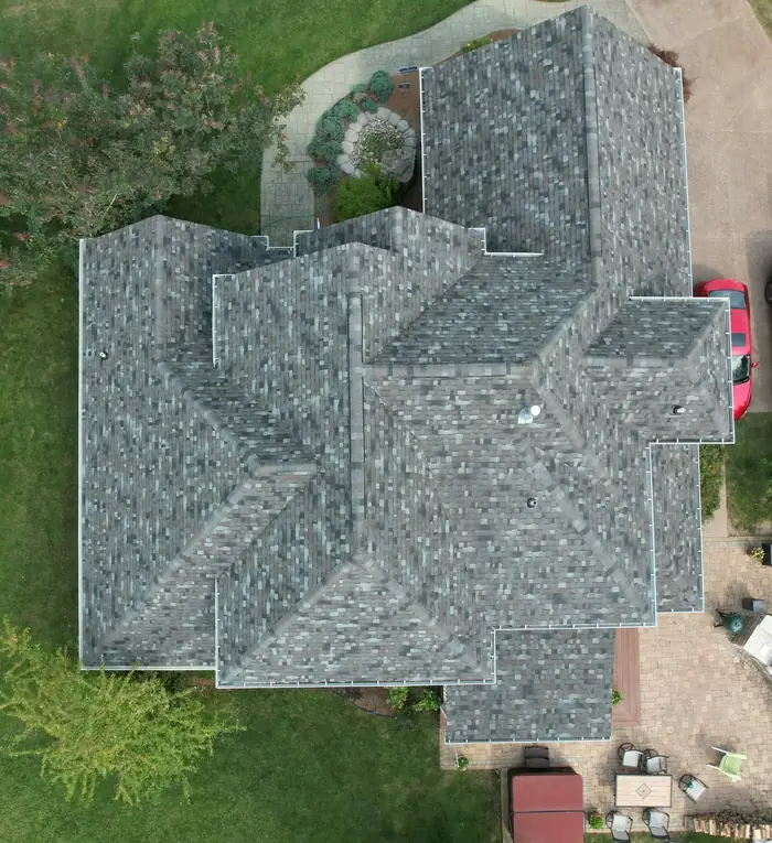 A large gray roof with many hips and valleys, straight down from a drone